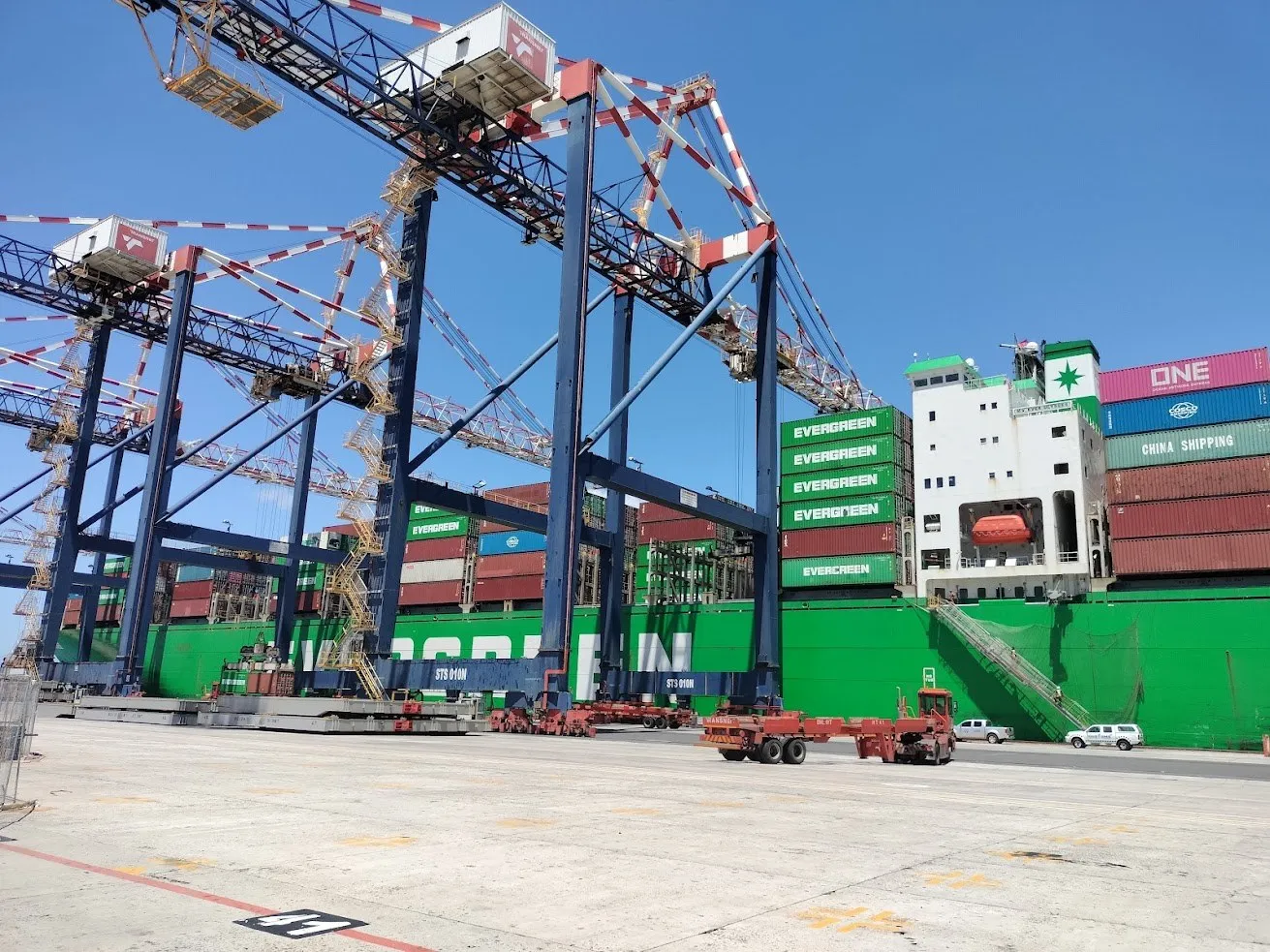 A container ship being worked by ship-to-shore gantry cranes at a container terminal