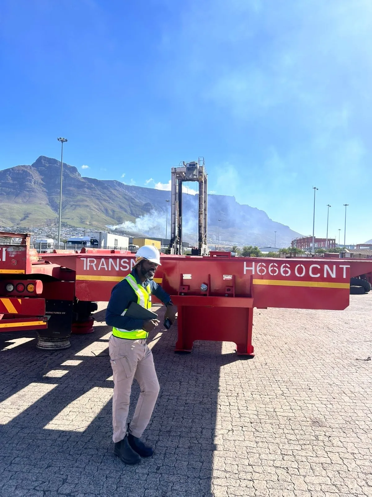 Container handling equipment at the Cape Town port yard, with Table Mountain behind