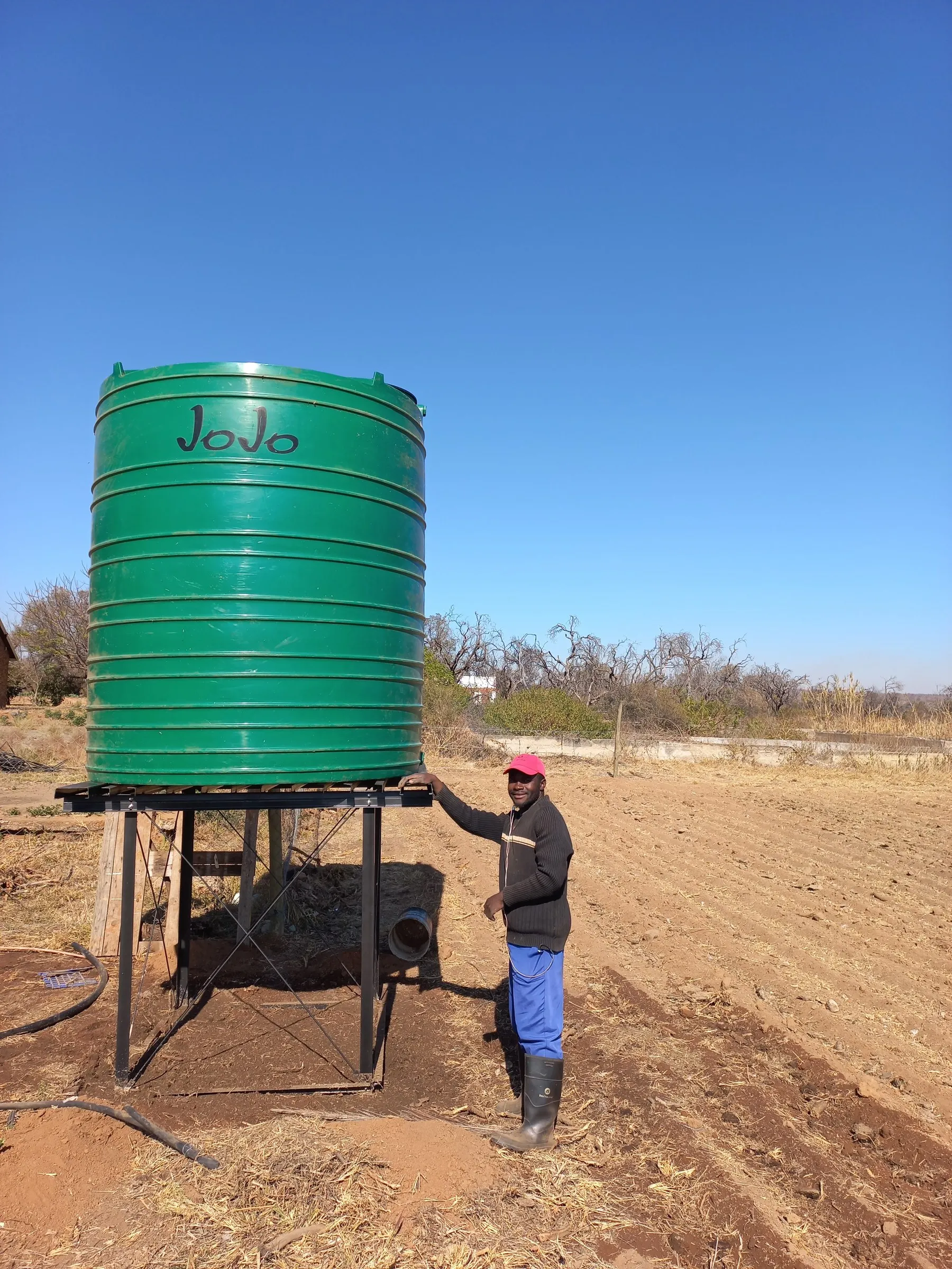 A farmer beside an elevated water storage tank